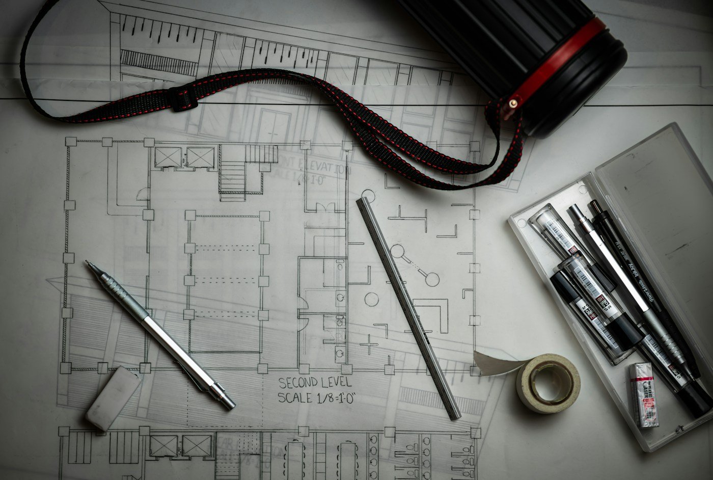 Architectural drawings and drafting tools used to plan a residential construction project